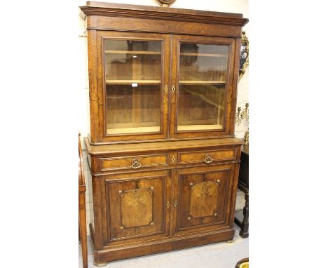 19th Century French walnut bookcase, the moulded cornice above two glazed doors, the base with two drawers and panel doors be