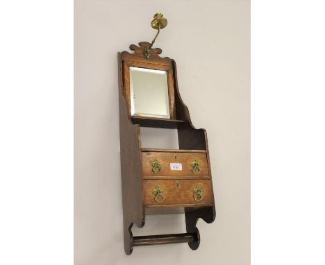 19th Century oak wall mounted shaving bracket with brass candle arm and rectangular bevelled mirror above a shelved centre wi