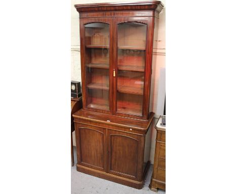 Victorian mahogany bookcase, the moulded cornice above a pair of glazed doors enclosing adjustable shelves, the base with two