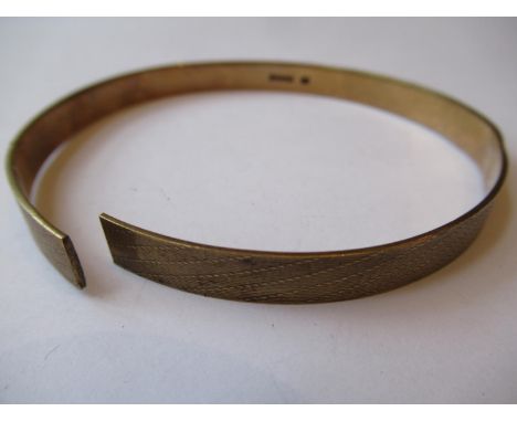 9ct Gold bangle with engine turned decoration (at fault), 19.5g 