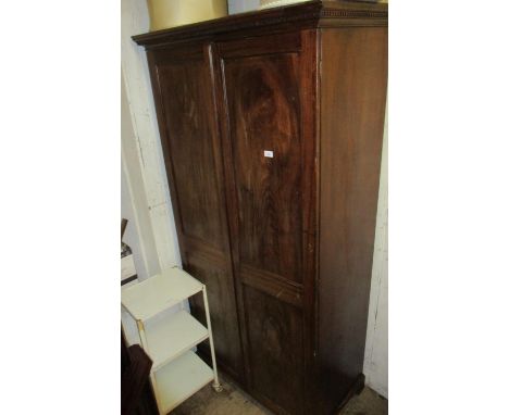 19th Century mahogany wardrobe having moulded key pattern cornice above two double panelled doors raised on shaped bracket fe