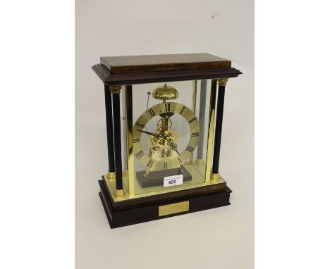 Modern mantel clock, the polished wood and glazed case housing a gilt chapter ring with Roman numerals and subsidiary seconds