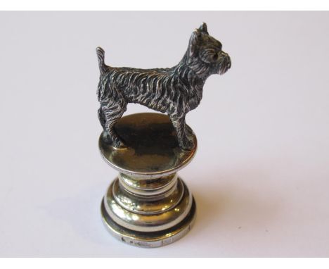 Small silver seal in the form of a Scottish terrier with ruby set eyes, on a circular plinth base, 1in highGilding worn on pl