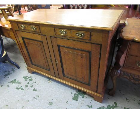 Regency oak side cabinet, the moulded top above two drawers with oval brass handles and two rectangular fielded panelled door