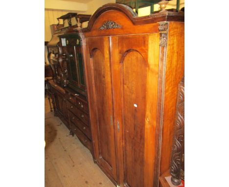 19th Century Continental walnut wardrobe, the broken arch top with turned finials above a pair of arched panel doors enclosin