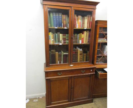 Late 19th / early 20th Century walnut bookcase, the moulded cornice above a pair of glazed doors enclosing adjustable shelves