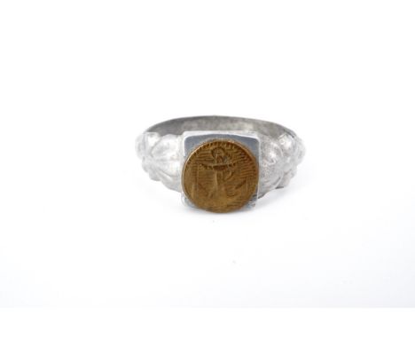 A Great War trench art finger ring in aluminium alloy faced with a Naval brass fowled anchor device