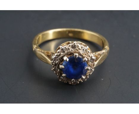 A sapphire and diamond flowerhead cluster ring, the central sapphire of approximately .65 ct claw set on an 18 ct gold shank 