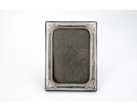 A silver photograph frame, decorated with Celtic influenced interlace, 14.5 cm x 11 cm