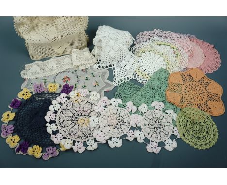 A collection of vintage handmade doilies, ornamental mats and shelf accents or edging, including pastel-toned crocheted pansy