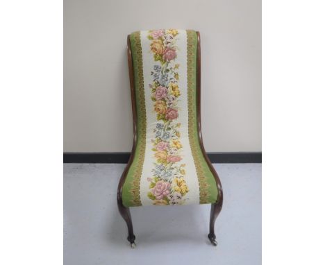 A Victorian mahogany nursing chair upholstered in a floral tapestry fabric