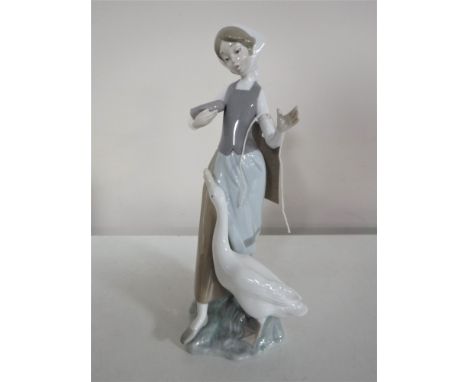 A Lladro figure of a girl feeding a goose