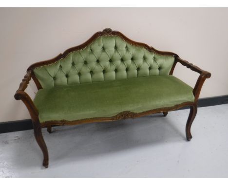 An Italianate window seat upholstered in a green button fabric 