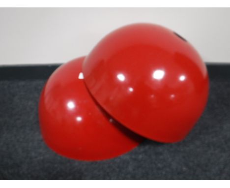 A pair of red metal industrial style light fittings