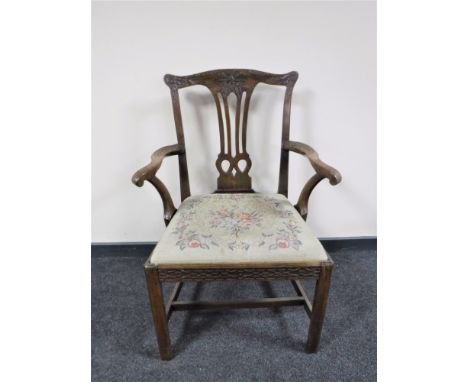 A carved Georgian armchair with a tapestry upholstered seat