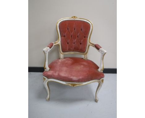 A white and gilt French armchair upholstered in a pink button dralon
