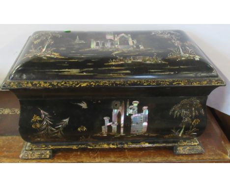 A 19th century papier mache tea caddy, with inlaid mother of pearl and gilded decoration, the interior fitted with two lift o
