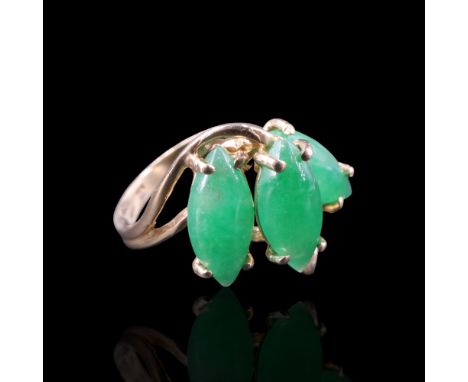A jade crossover ring comprising an asymmetric arrangement of three navette-shaped cabochons, claw-set between the bifurcated