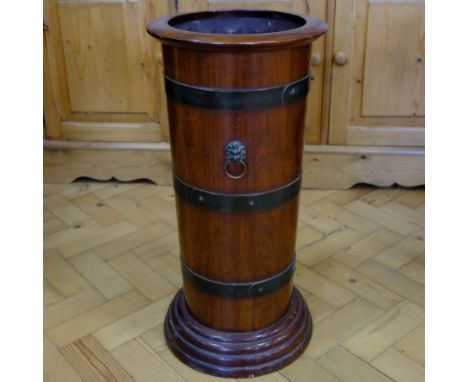 A late 19th / early 20th Century coopered mahogany stick and umbrella stand, of slender tapering form with lion's mask and ri