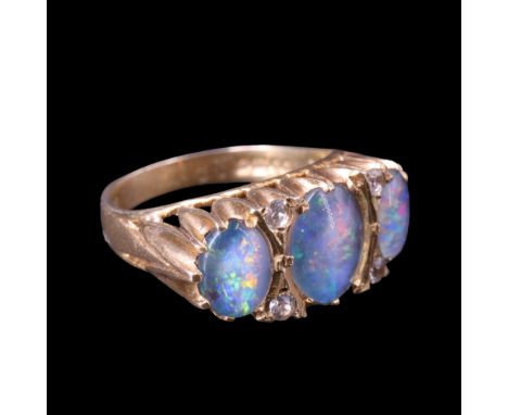 A 1970s opal and white stone dress ring comprising three graded opal cabochons, claw-set on a raised gallery between the tape