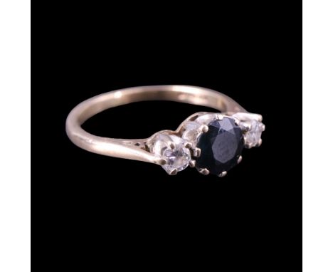 A 1980s three-stone sapphire and diamond finger ring, the central round-cut stone of approx 0.6 ct, claw-set between two furt