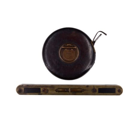 A vintage Chesterman 66-feet steel tape measure together with a brass-mounted ebony spirit level, latter 20 cm