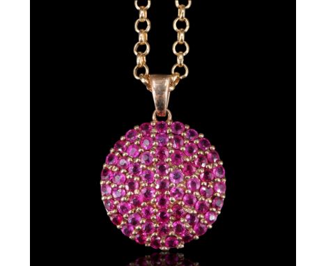 A pink ruby pendant comprising a multitude of round-cut stones of approx 2 mm diameter, millegrain-set in a convex, circular 