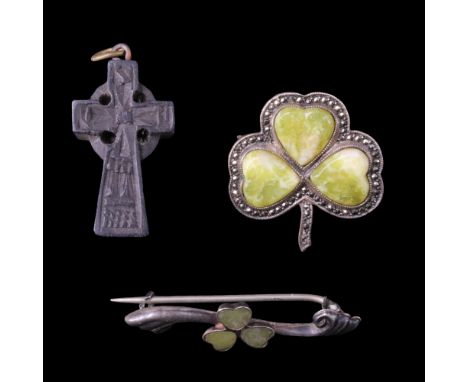 An Irish caved bog oak Celtic cross pendant together with two Connemara marble shamrock brooches