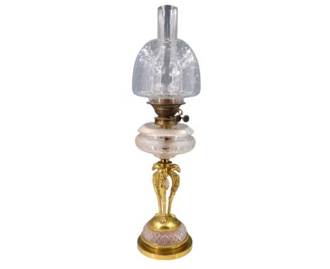 A fine Victorian oil lamp having a Duplex burner and facet cut glass reservoir raised on three grotesque cast brass columns h