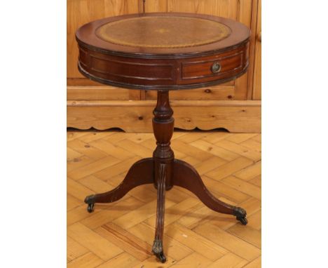 A Georgian-style drum-top mahogany occasional or lamp table, having a tooled leather skiver and standing on four reeded legs 