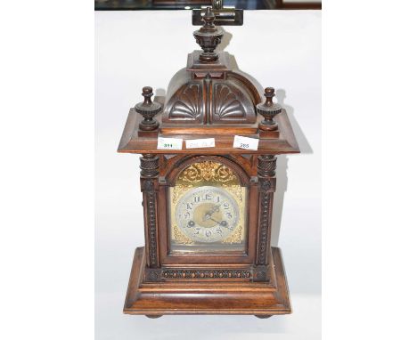 A late 19th Century mantel clock, the wooden case of architectural form with silvered dial