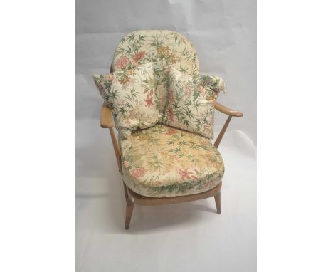 An Ercol light elm framed stick back armchair with strap work seat