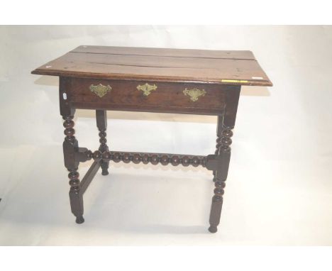 An 18th Century and later oak single drawer side table raised on a bobbin turned frame and fitted with brass handles, 91cm wi