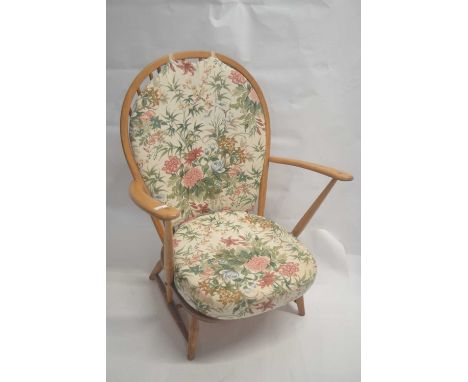 An Ercol light elm low hard seated and stick back armchair