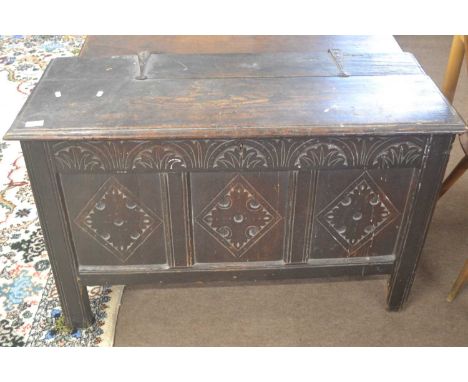 An 18th Century oak coffer of typical form with two plank top opening to an interior with candle box, front with three panels