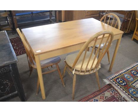 An Ercol light elm rectangular kitchen table together with three stick back chairs (non matching designs), table 122cm long (