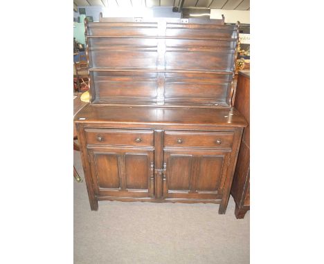 A dark Ercol dresser with three shelf back over a base with two drawers and two doors, 130cm wide