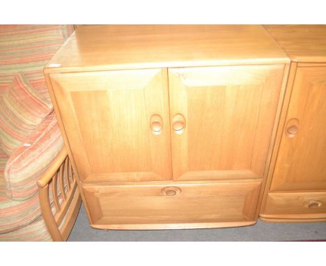 An Ercol light elm television cabinet with two doors and a drop down flap to base, 85cm wide