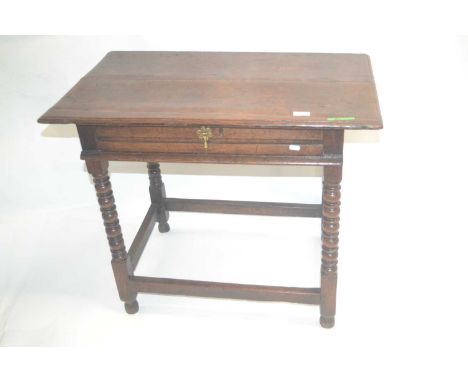 An 18th Century oak single drawer side table raised on bobbin turned legs with an all round base stretcher, 85cm wide