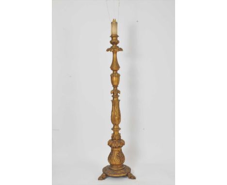 A gilded carved wooden standard lamp, carved throughout with acanthus and further shallow carved detail, over a circular base