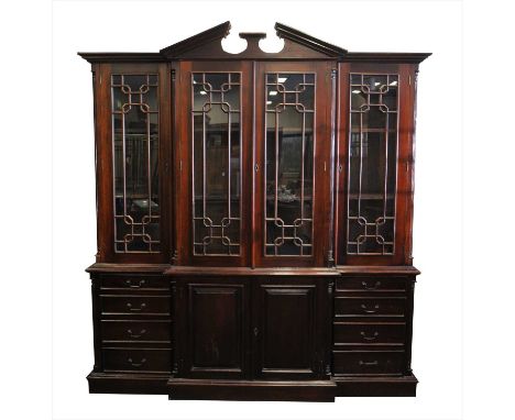 A large reproduction architectural mahogany bookcase, with a broken pediment over a broken alignment of hinged glazed panelle