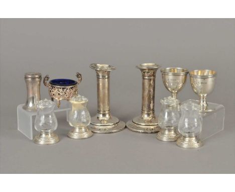 A pair of short silver mounted candlesticks, Birmingham, together with two silver egg cups, Goldsmiths &amp; Silversmiths Co 