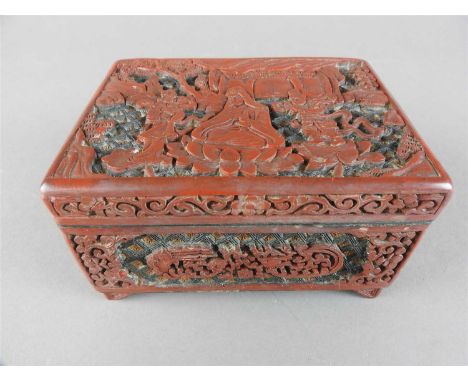 A Chinese three colour cinnabar lacquer box, Qing Dynasty, late 19 th century, the rectangular top carved with guan yin seate