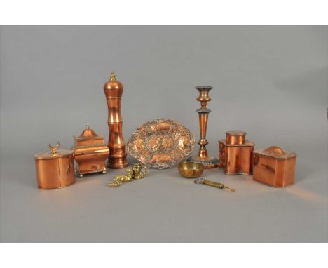 A collection of decorative copper wares to include four caddies of varying form, a large pepper mill, candle stick, embossed 