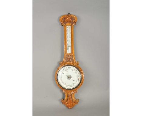 An early 20th century carved oak wall-hanging banjo barometer, with a white porcelain dial and thermometer set within a frame
