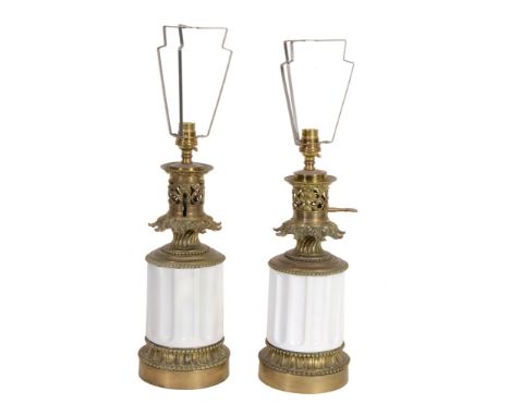 A pair of gilt metal mounted white glazed ceramic table oil lamps A pair of gilt metal mounted white glazed ceramic table oil