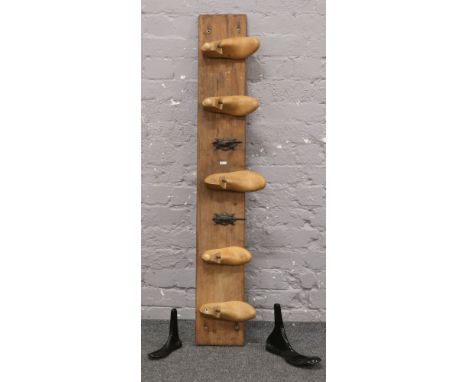 A wooden coat rack with wooden shoe / cast iron hooks. 