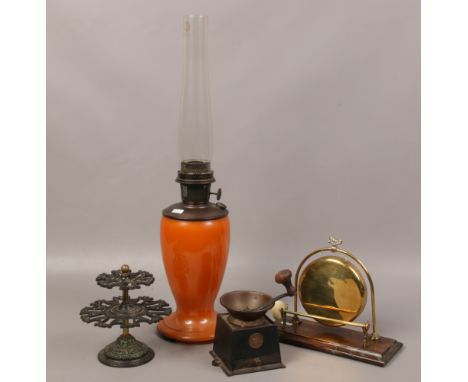 A collection of metalwares to include coffee grinder, brass dinner gong, rotating stand and amber glass oil lamp. 