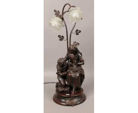 A bronzed composite twin branch figural table lamp formed as mother and child, marked Confidence. 