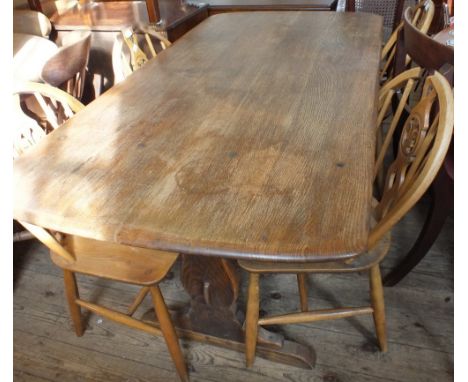 A rectangular Ercol dining table and four wheel back dining chairs